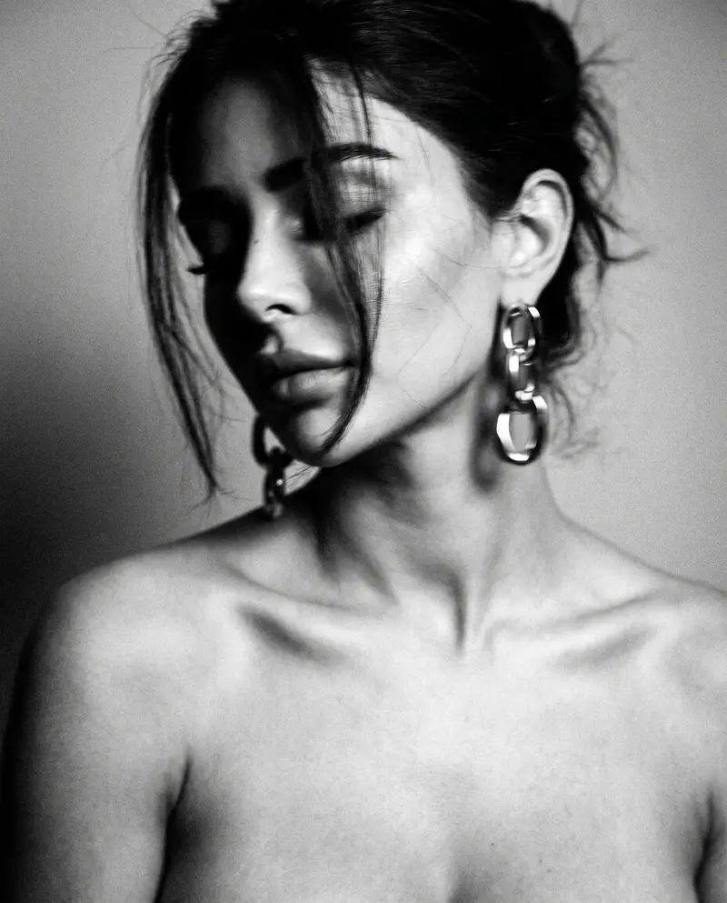 Close profile with chain-link earring, eyes closed, bare shoulders
